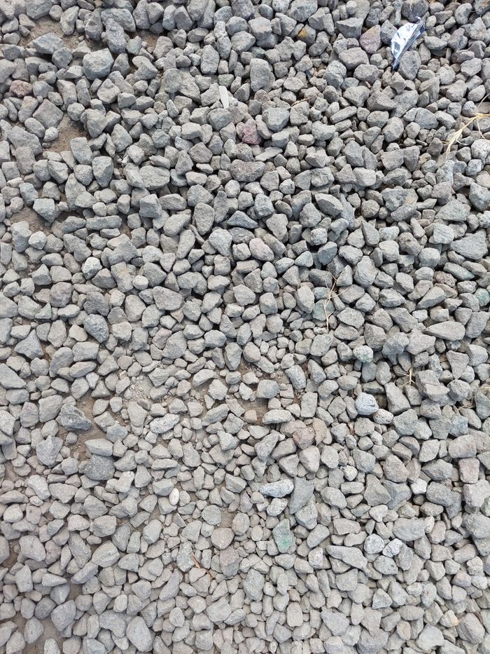 Close-up view of scattered grey gravel stones on the ground, creating a natural texture.